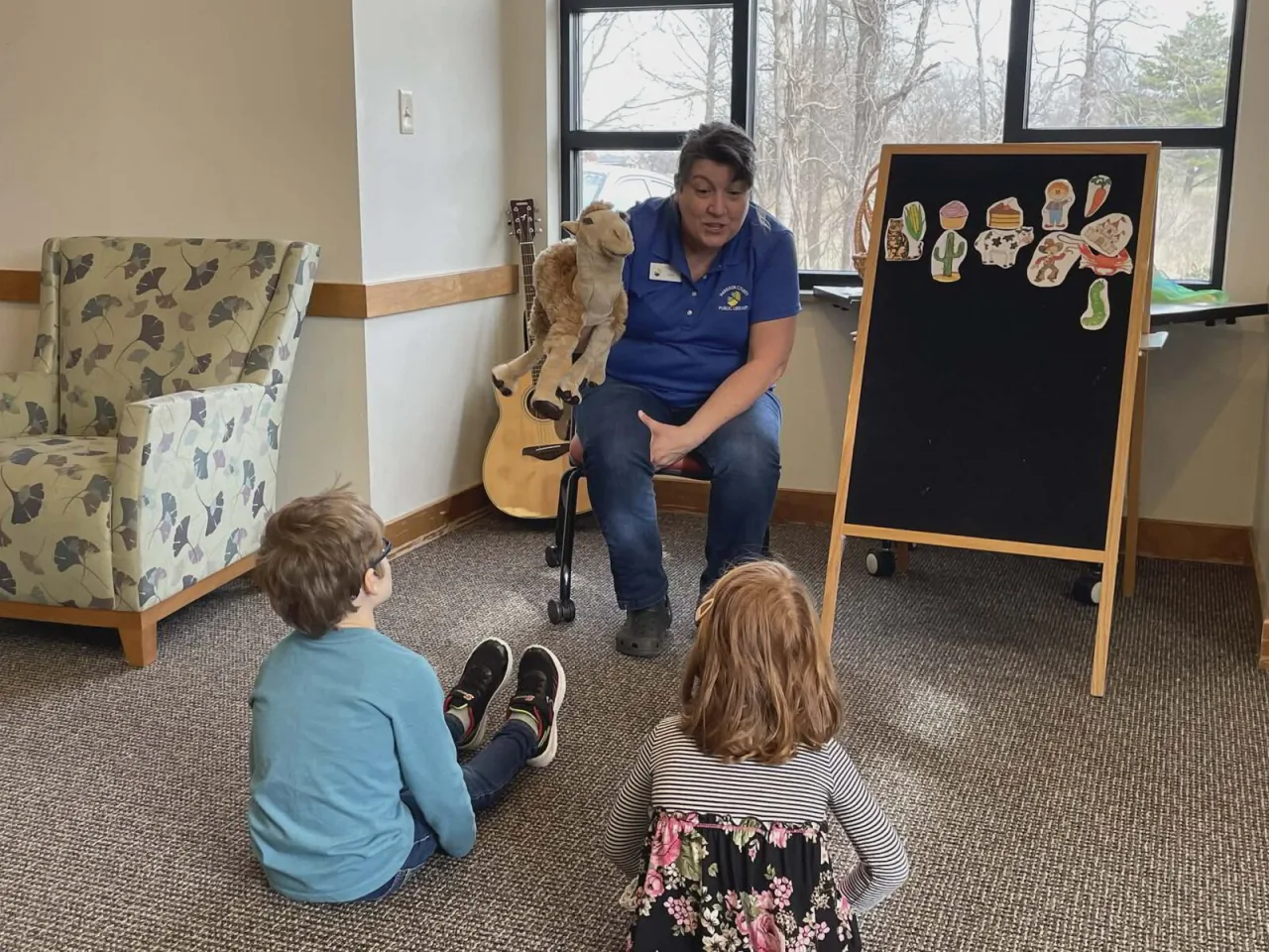 A teacher reads to young students in a rural classroom