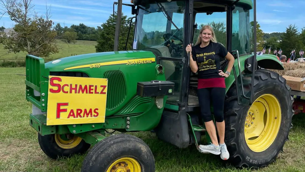Sarah at Schmelz Farms with a John Deere tractor